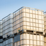 white ibc container in outdoor stock yard of factory, white plastic chemical tanks